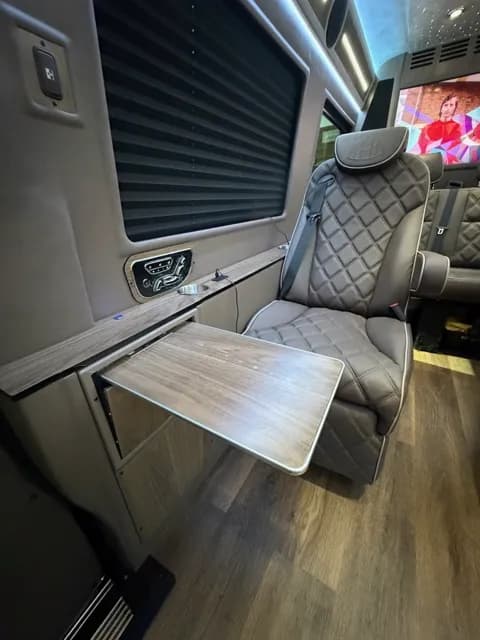 Fold-out wood-trimmed table between the captain's chairs