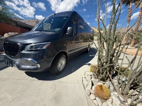 Maybach-grille executive Sprinter van against a desert backdrop