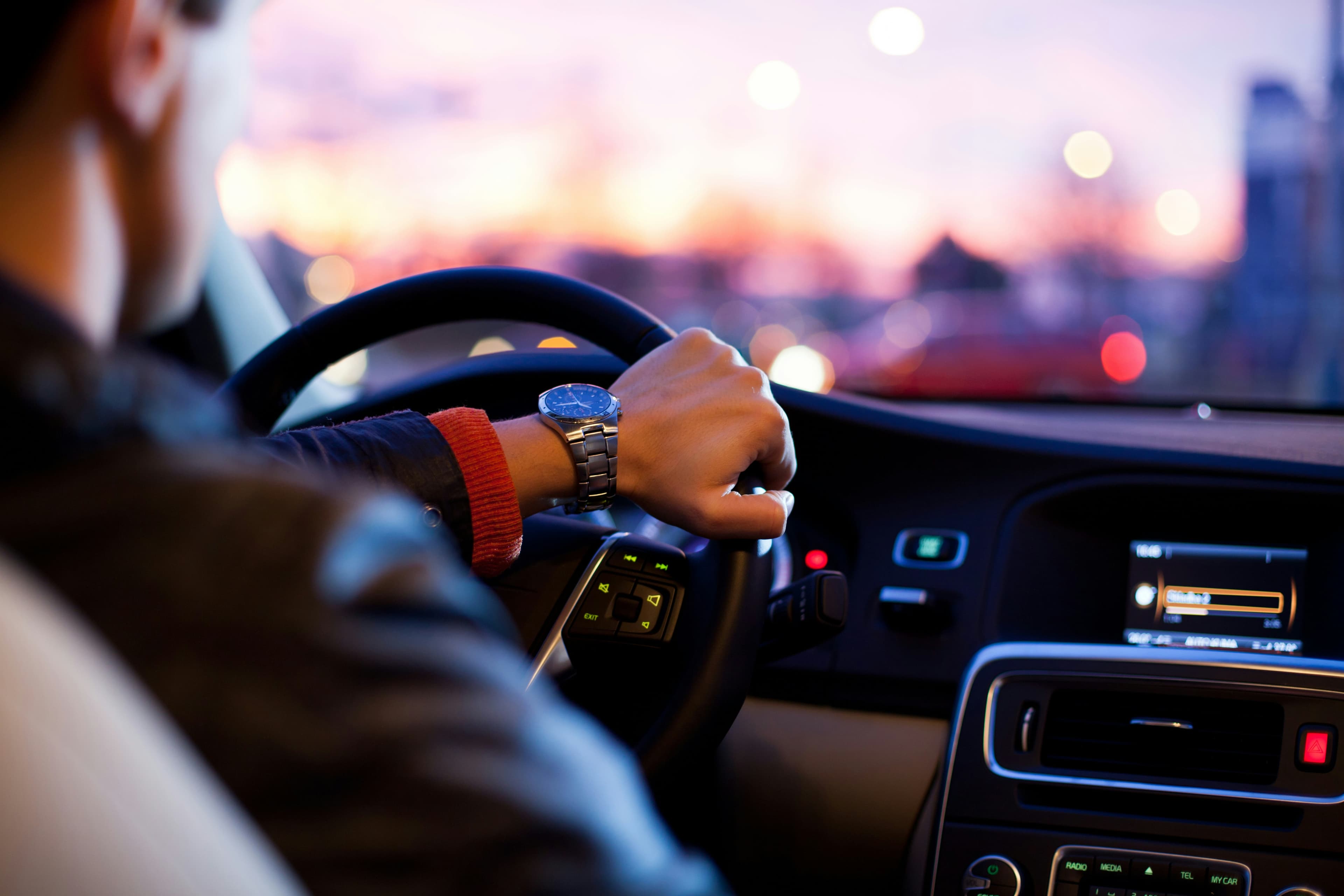 A Stratos chauffeur at the wheel at dusk